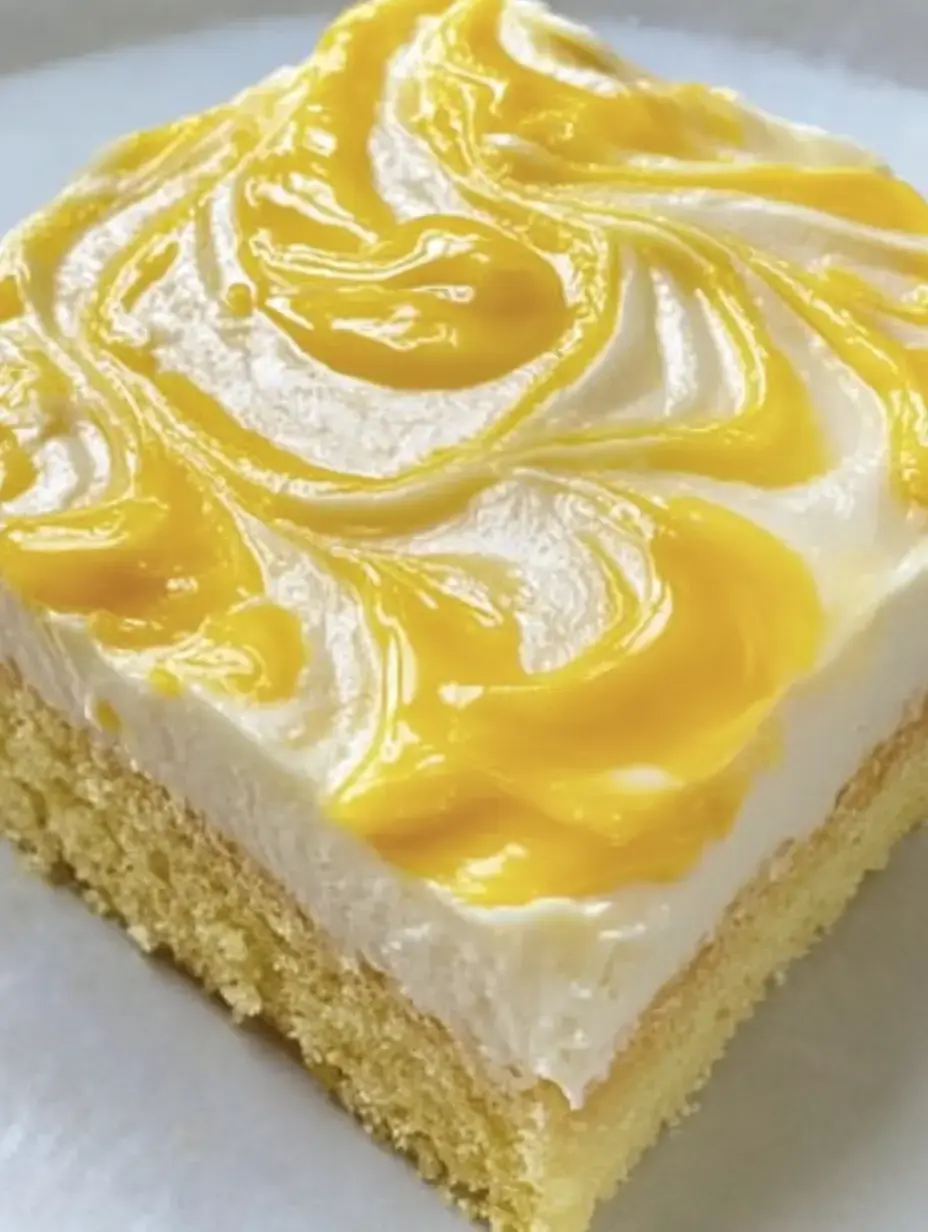 Ein Stück Kuchen mit einer cremigen weißen Schicht und gelber Fruchtsauce auf der Oberseite.