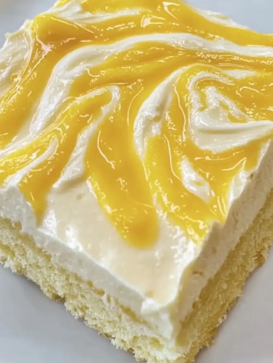 Ein Stück Kuchen mit einer cremigen Schicht und einer gelben Fruchtsoße obenauf.
