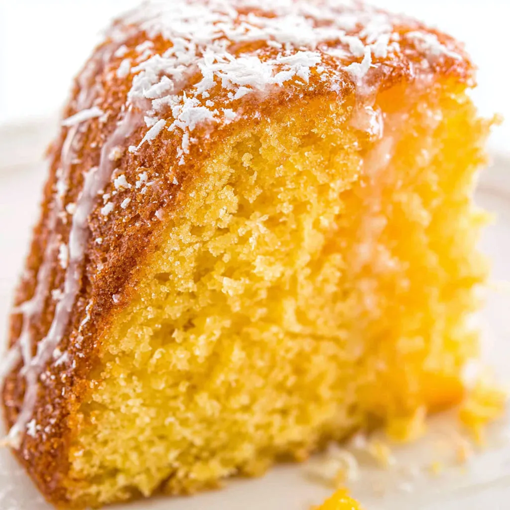 A slice of rum cake with powdered sugar on top.