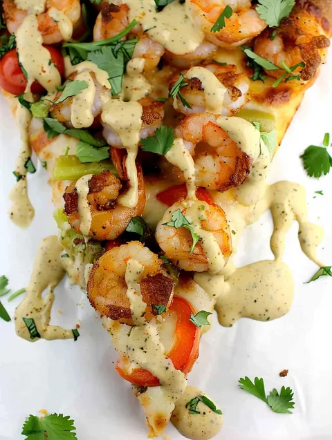 A slice of pizza with shrimp and sauce.