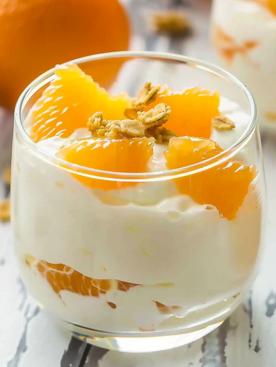 A glass of orange cream dessert.
