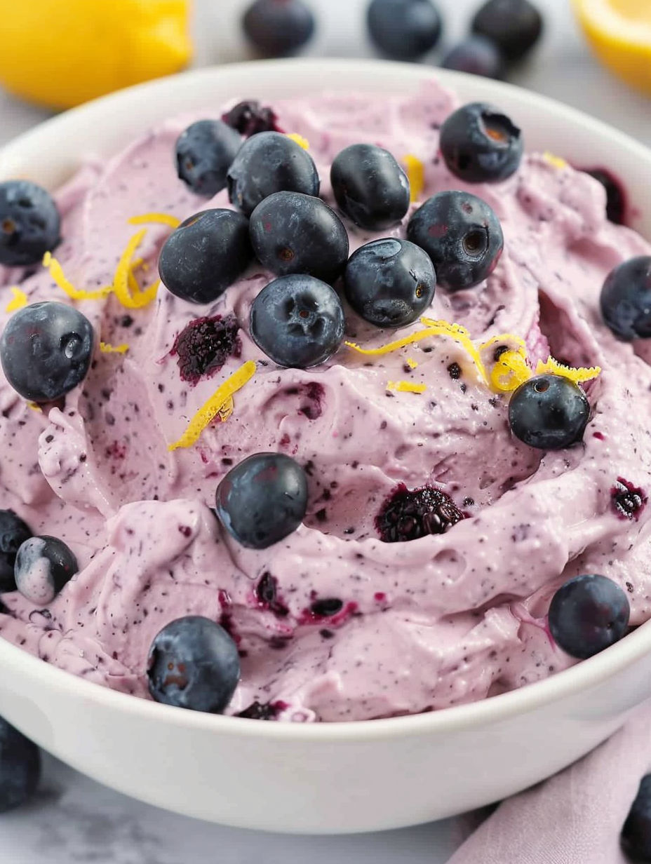 A bowl of blueberry fluff with blueberries on top.