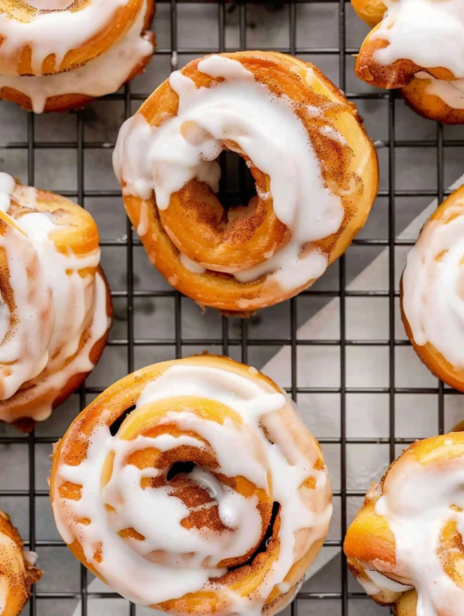 A tray of donuts with white frosting and a hole in the center.