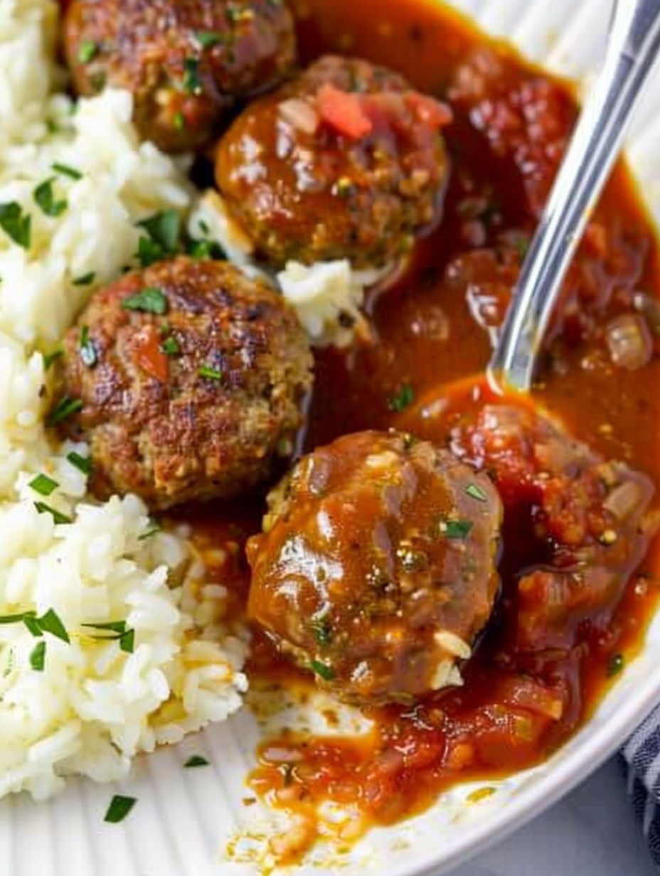 A plate of meatballs in a red sauce.