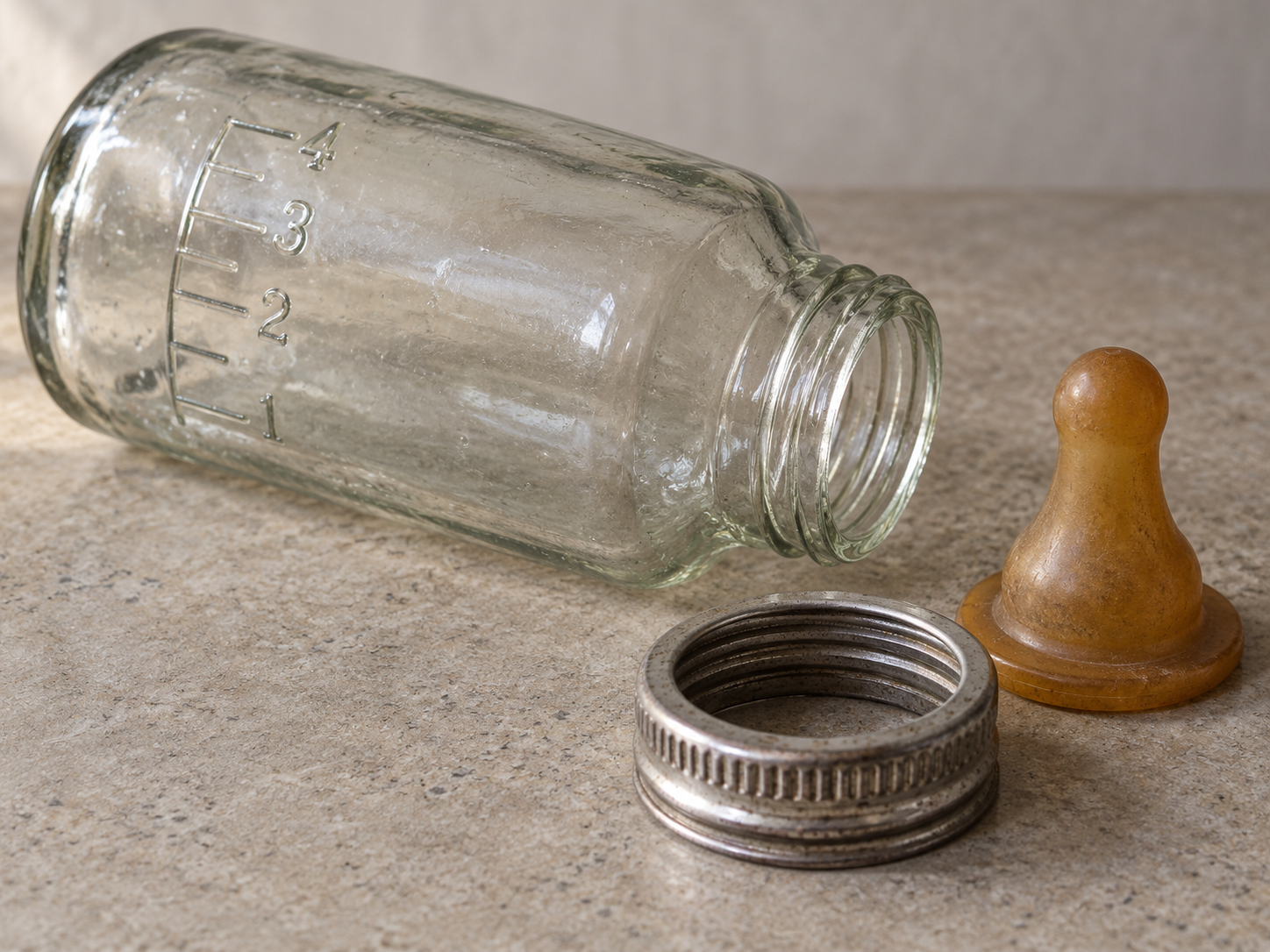 Nahansicht einer alten Glas-Babyflasche mit Sauger und Verschlussring.
