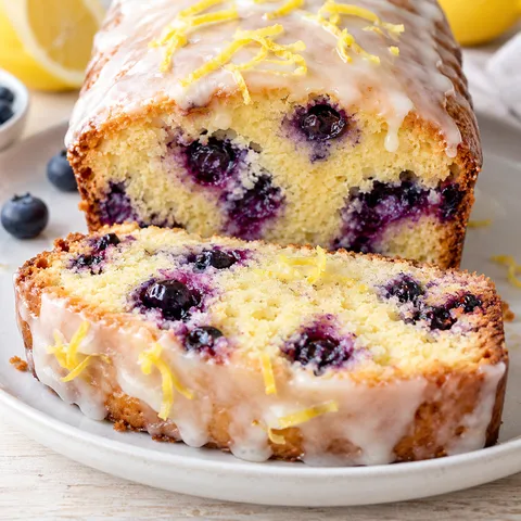 Blaubeer-Zitronen-Kuchen mit Zitronenglasur und violetten Beeren