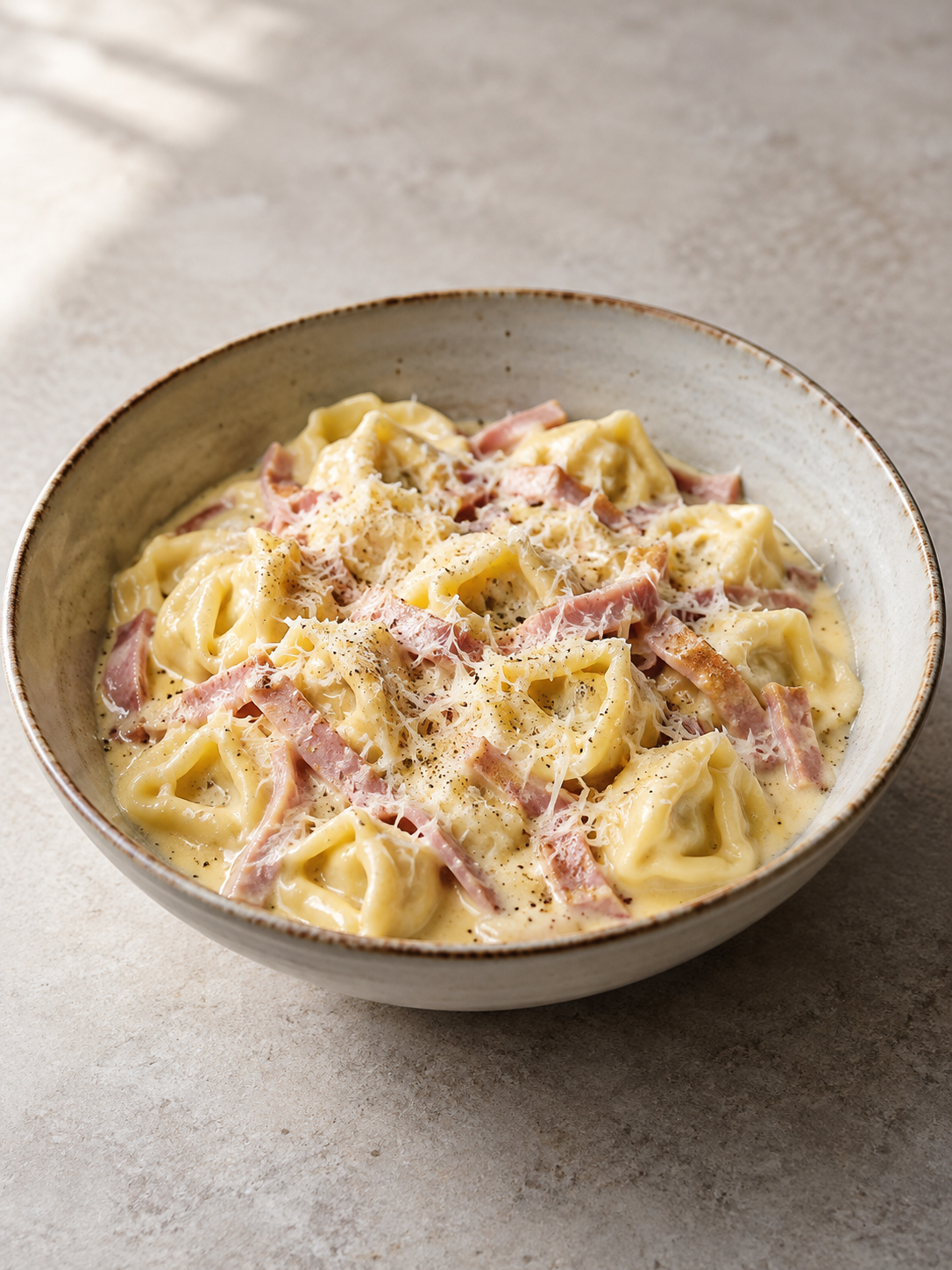 Cremige Tortellini in Schinken-Sahne-Soße im Hochformat