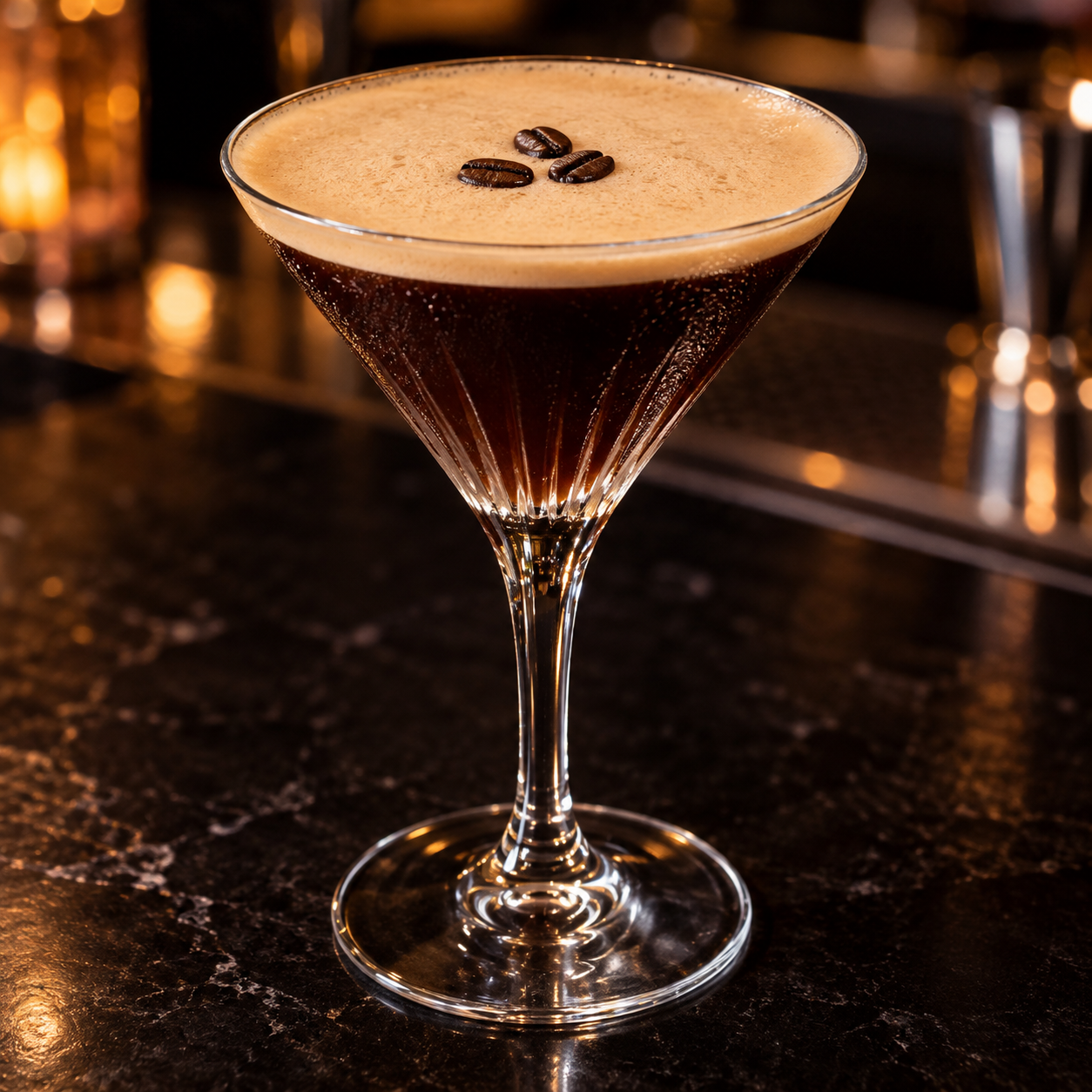 Espresso Martini mit heller Crema und drei Kaffeebohnen im Coupetteglas