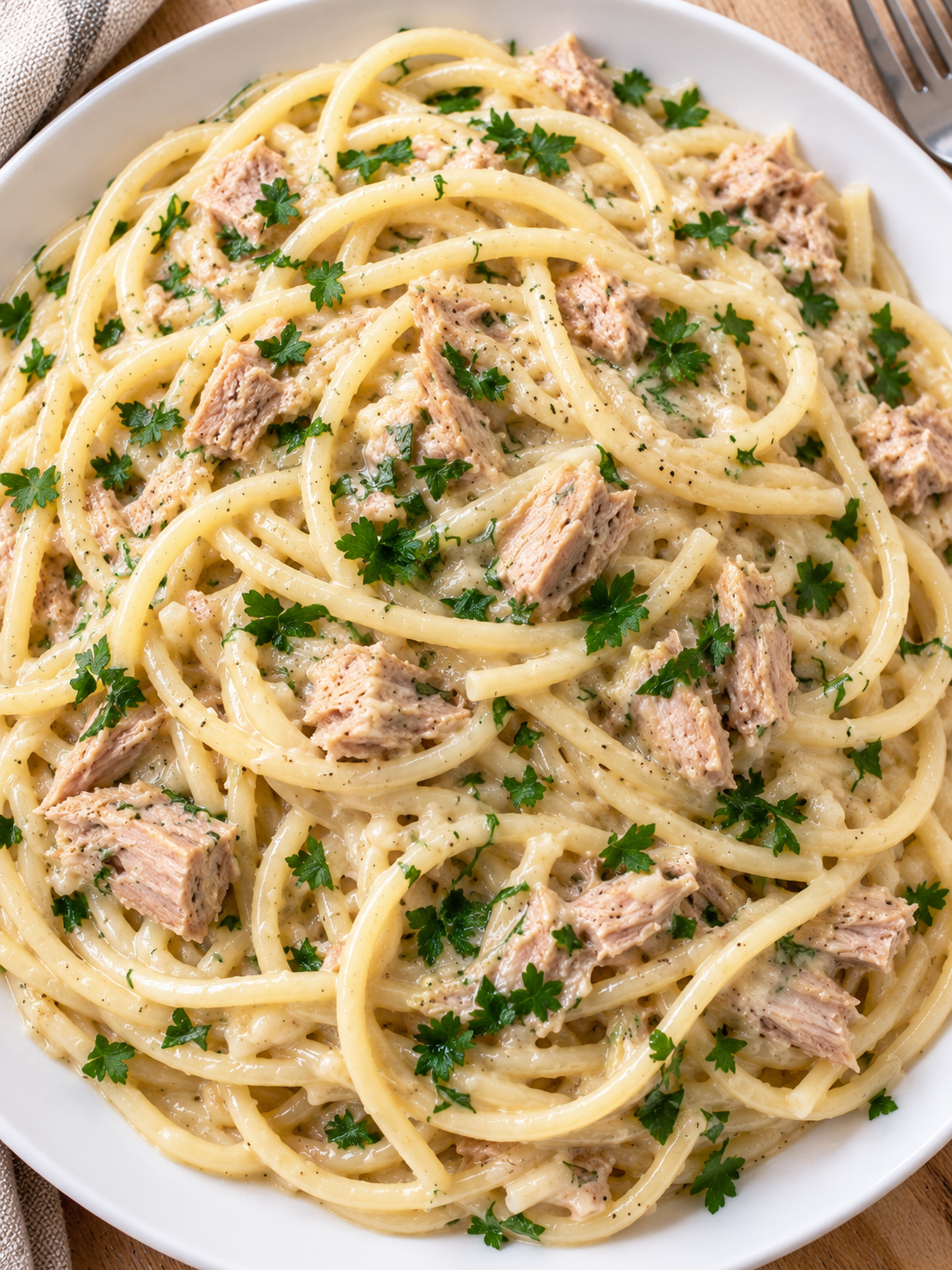 Cremige Thunfisch-Knoblauch-Spaghetti mit sichtbaren Fischstücken und Petersilie