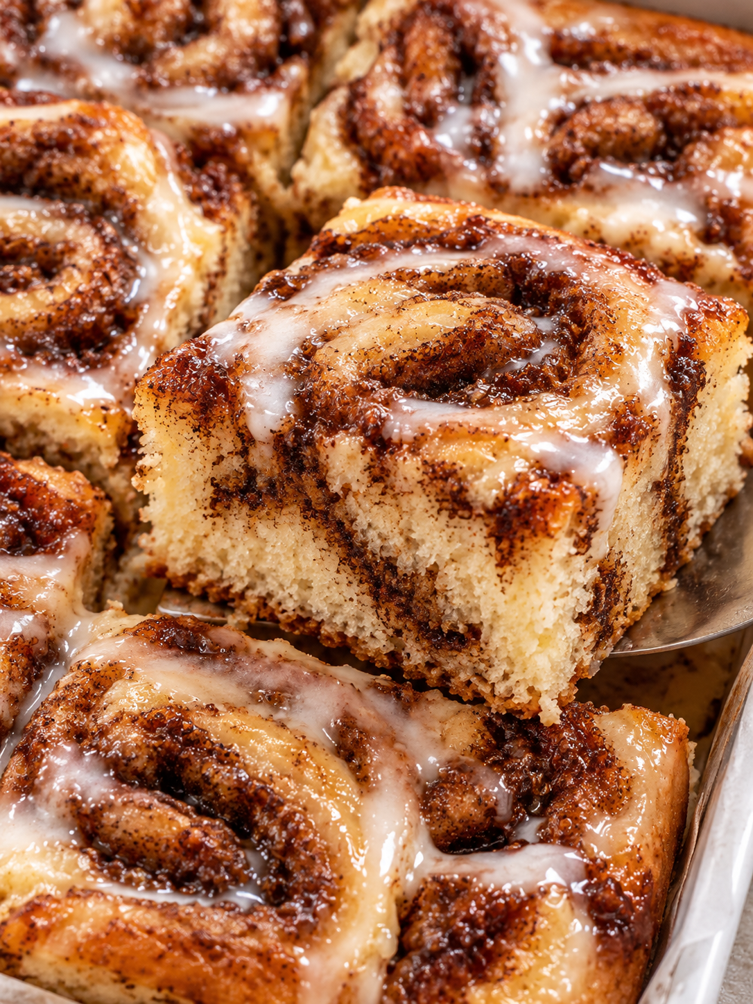 Saftige Stücke Zimtschnecken-Kuchen mit Glasur und Zimtstreifen