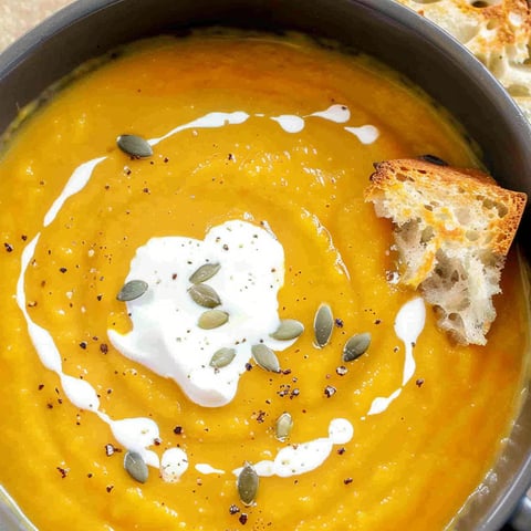 A bowl of soup with a piece of bread on top.