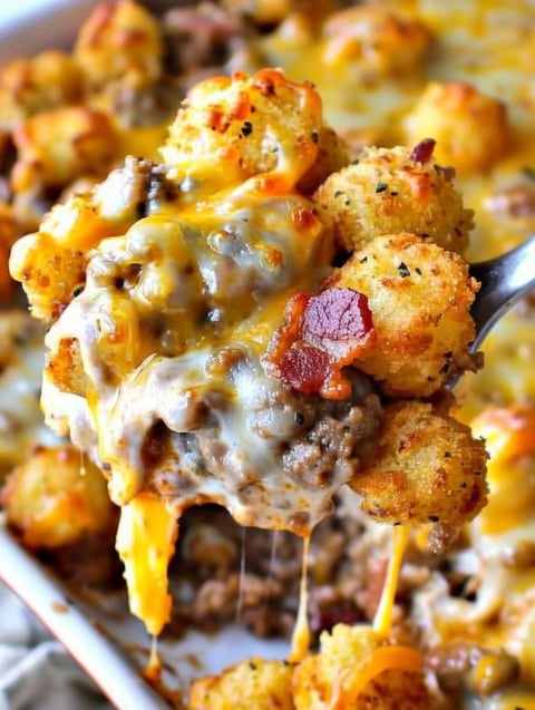 A fork is being used to eat a cheeseburger tater tot casserole.