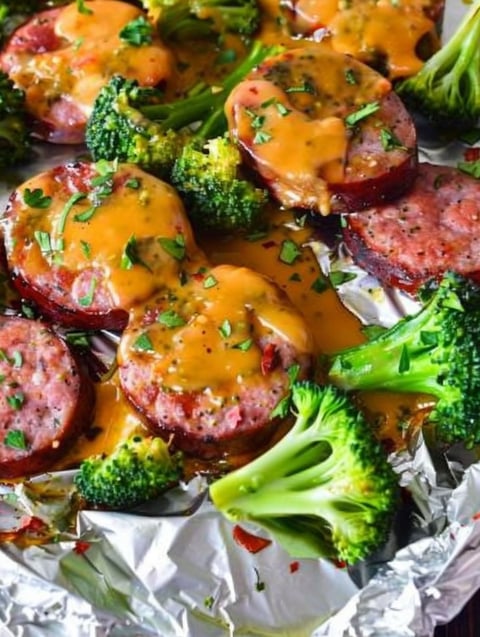 Sausage and broccoli on foil.