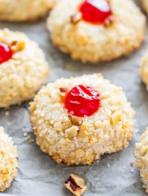 A plate of cookies with a cherry on top.