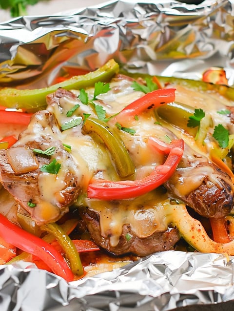 A foil packet of steak fajita with peppers and onions.