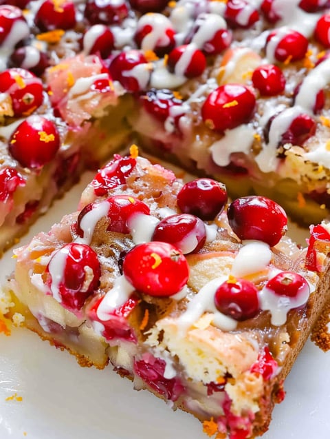 A slice of cake with cranberries and apples.