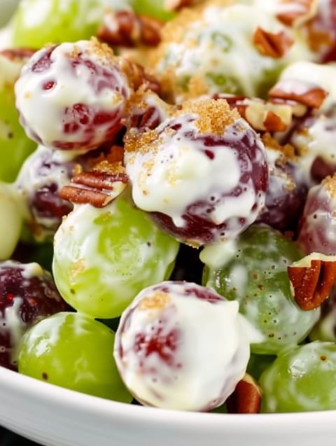 A white sauce is drizzled over a salad of grapes.